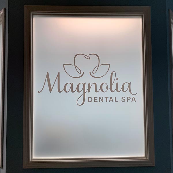 magnolia dental spa logo etched onto window